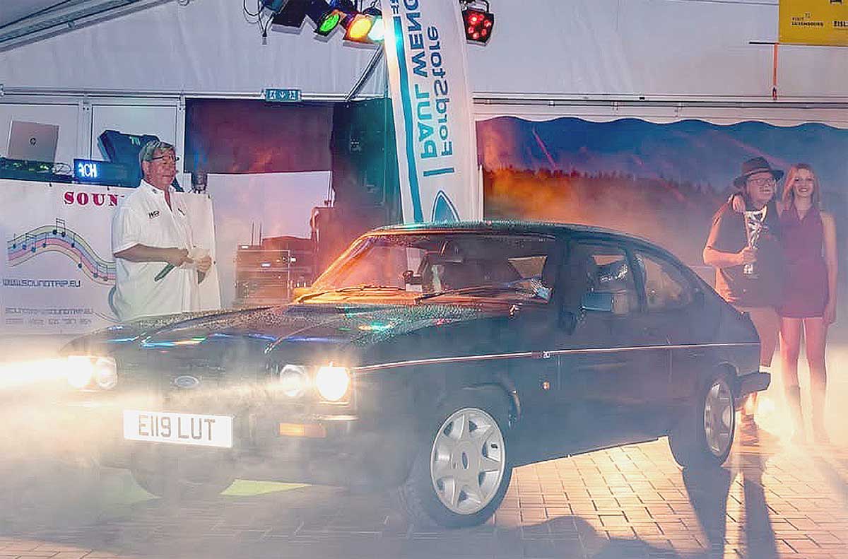 Beim Treffen der Capri Frenn Letzebuerg im letzten Jahr durfte sich Mick Ward (rechts mit Hut und Dame im Arm) über eine Trophäe freuen, mit der sein 280er ausgezeichnet wurde. Beim Treffen der Capri Frenn Letzebuerg im letzten Jahr durfte sich Mick Ward (rechts mit Hut und Dame im Arm) über eine Trophäe freuen, mit der sein 280er ausgezeichnet wurde.